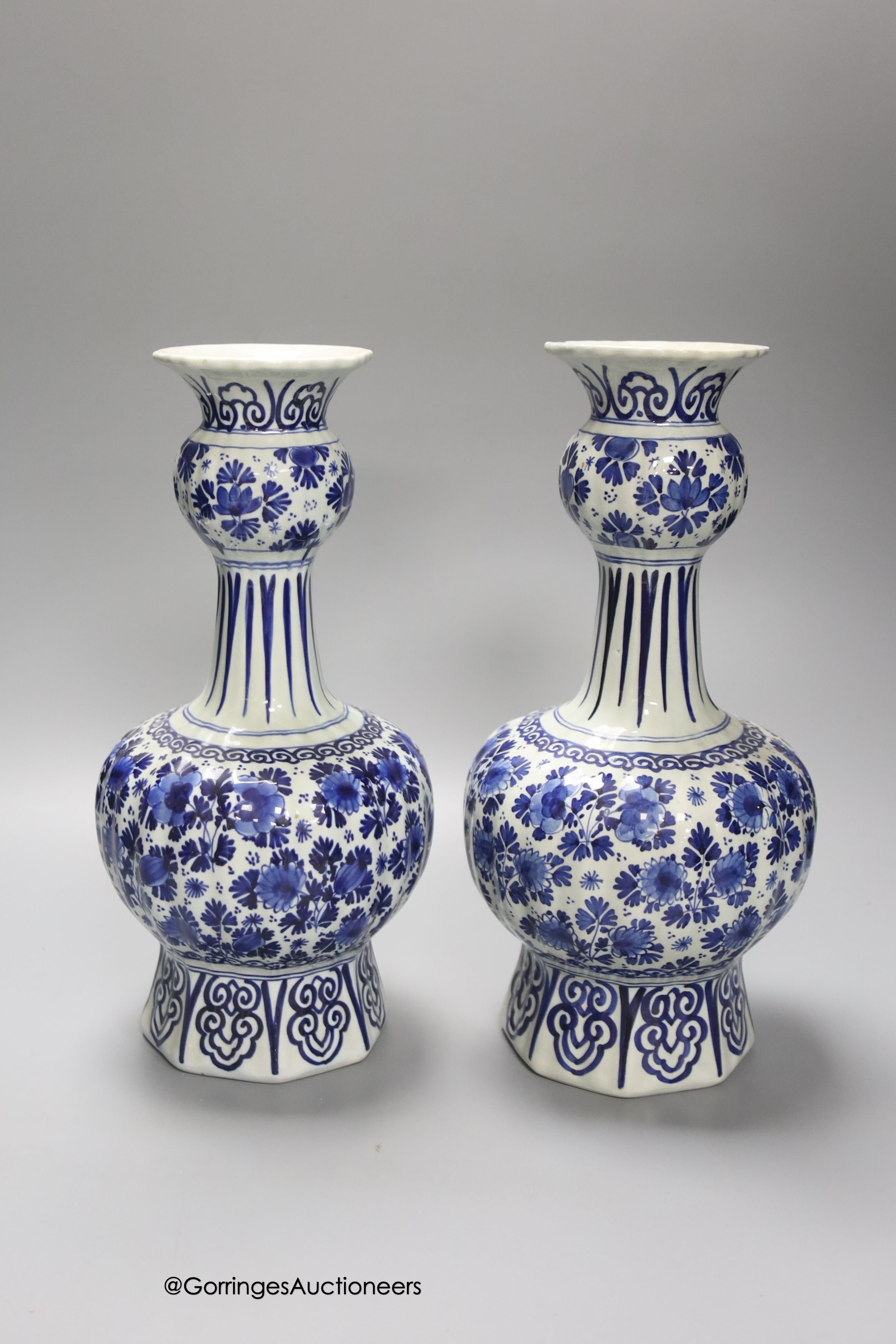 A pair of Dutch Delft blue and white vases, 29cm, a similar ovoid jar and cover and a bulbous jug